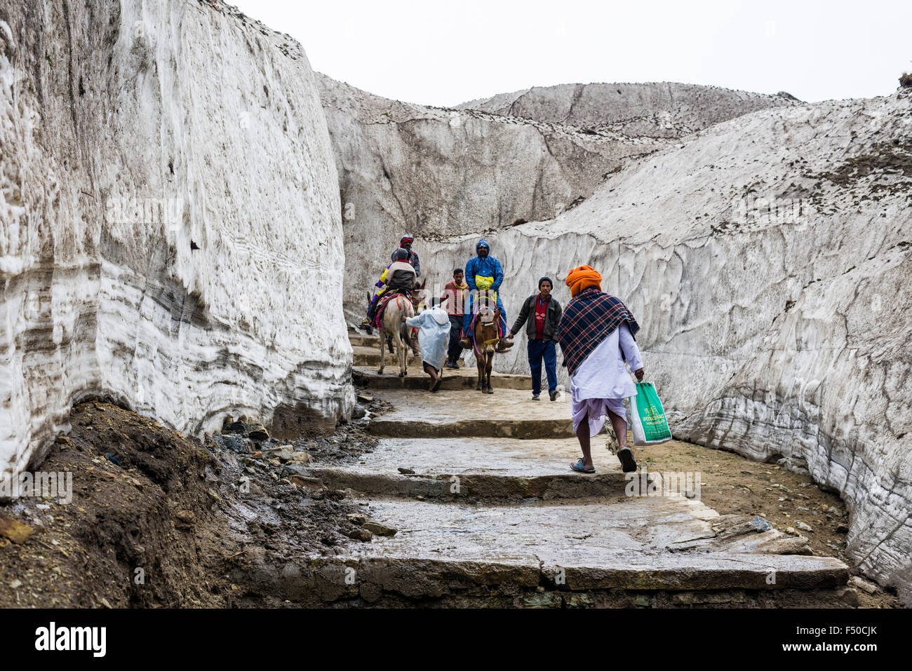 Los peregrinos tienen que atravesar un campo de nieve en la pista a kedarnath templo Foto de stock
