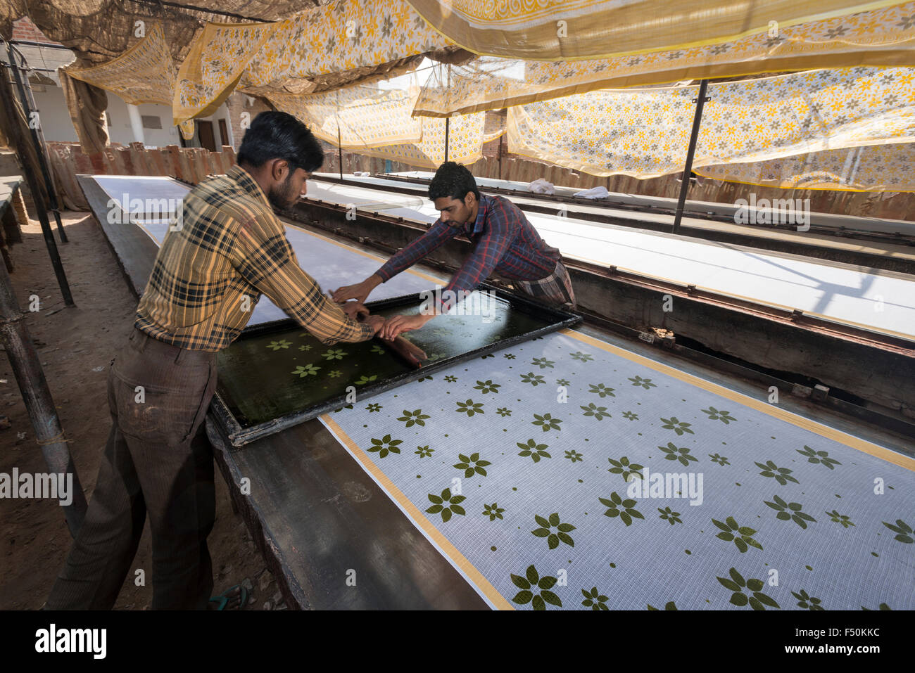 Dos hombres son los materiales de impresión para saris principalmente en la técnica tradicional a mano Foto de stock