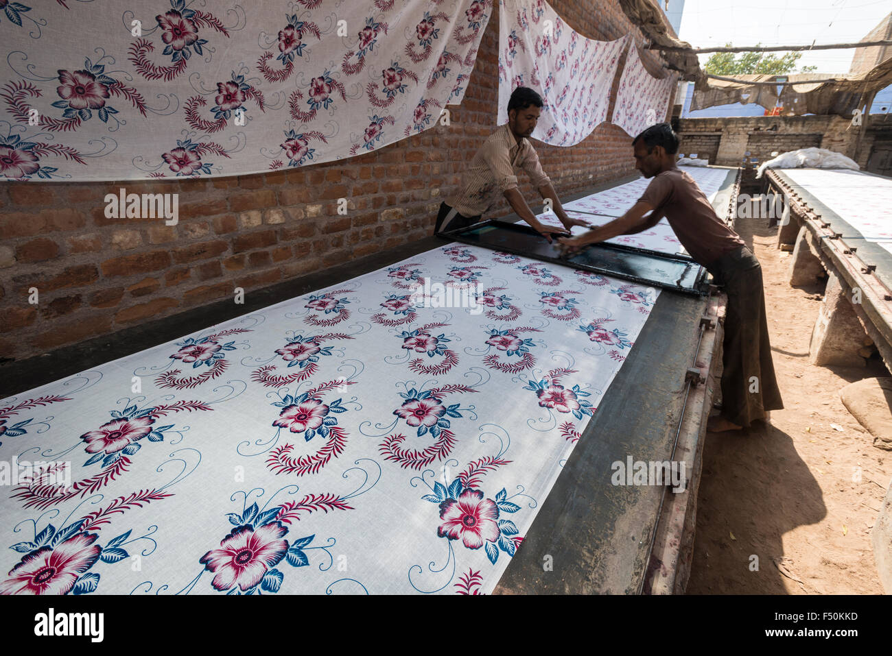 Dos hombres son los materiales de impresión para saris principalmente en la técnica tradicional a mano Foto de stock