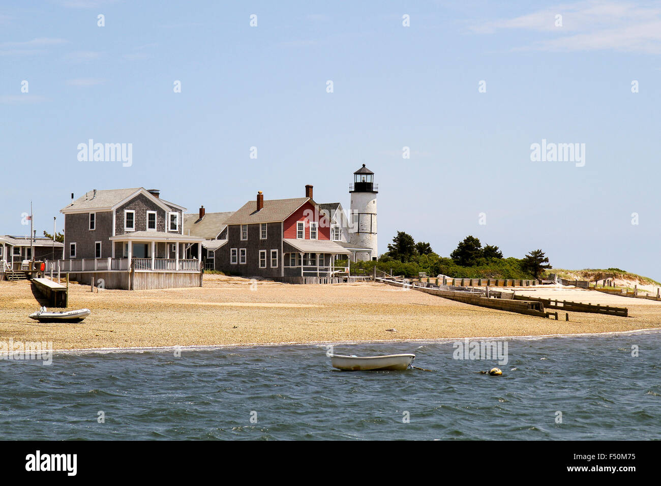 Casas aisladas y Sandy Neck faro visto desde el agua, en Cape Cod, Massachusetts Foto de stock