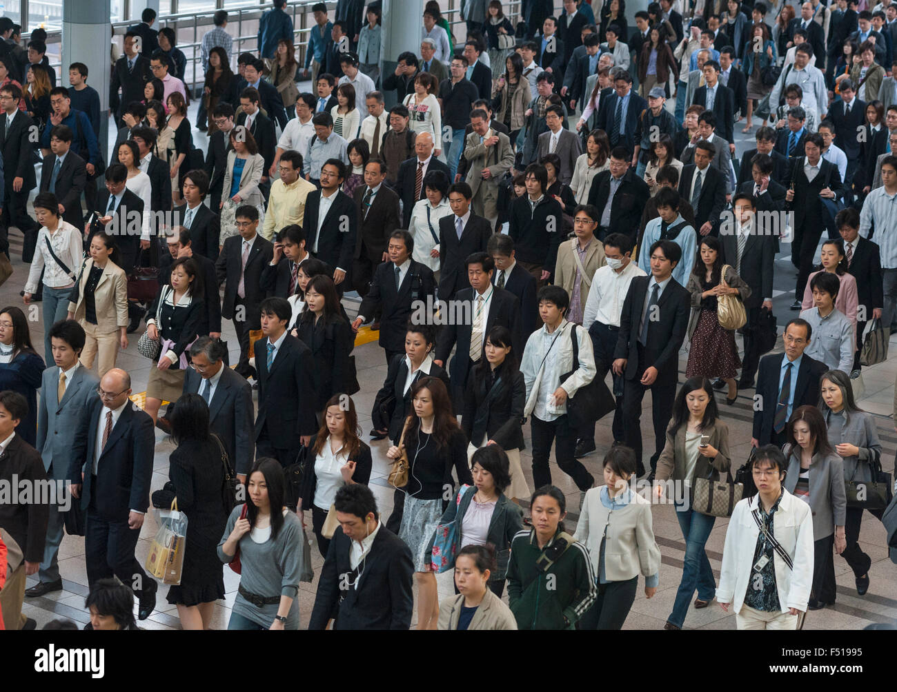 Muchos pasajeros caminar a través de la estación durante la hora punta de la mañana en el centro de Tokio, Japón Foto de stock