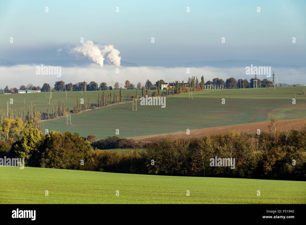 No fumar ecologic chimeneas en desde la fábrica oculta en niebla de la mañana a lo largo de paisaje rural Foto de stock