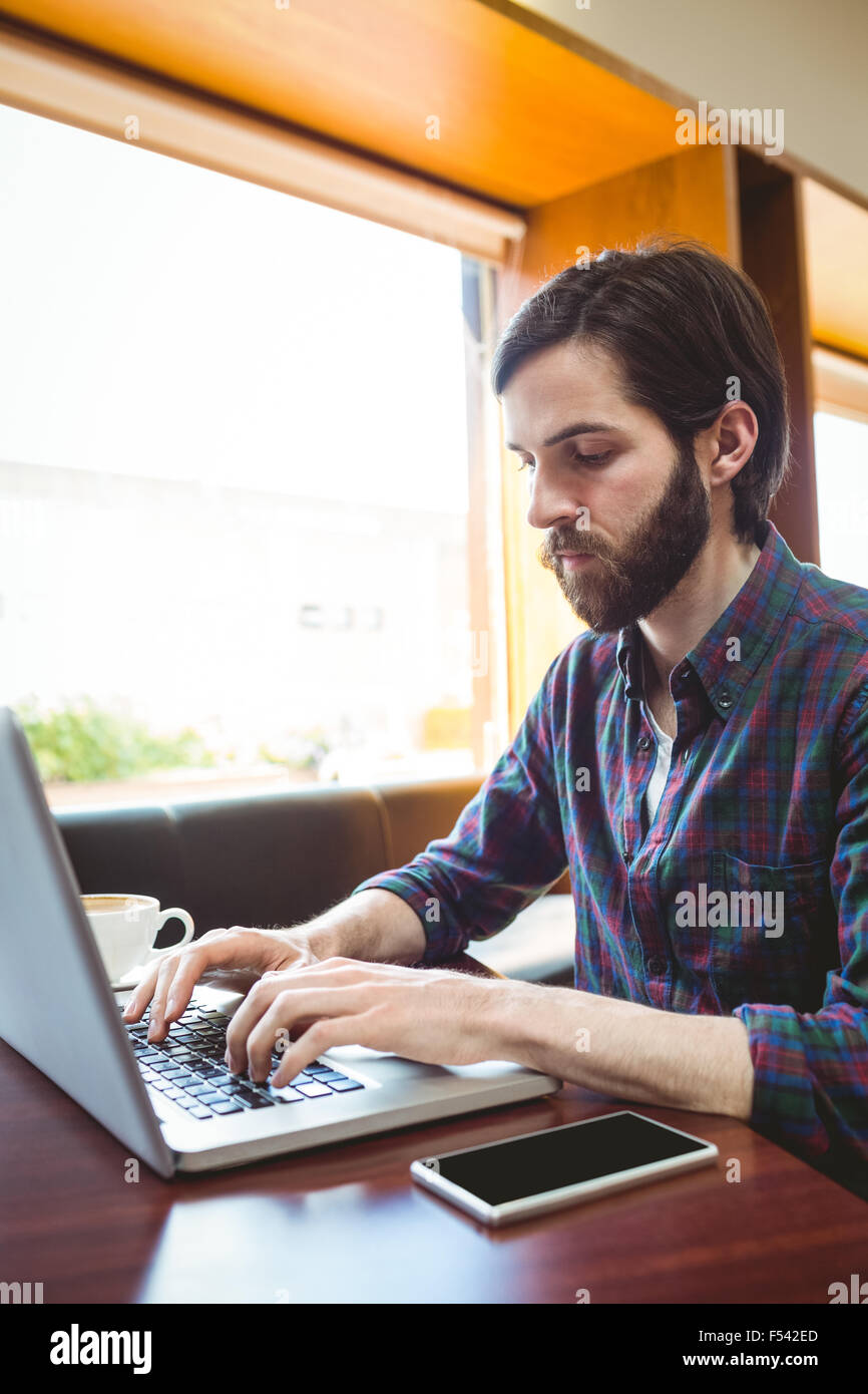 Hipster estudiante usando el portátil en la cantina Foto de stock