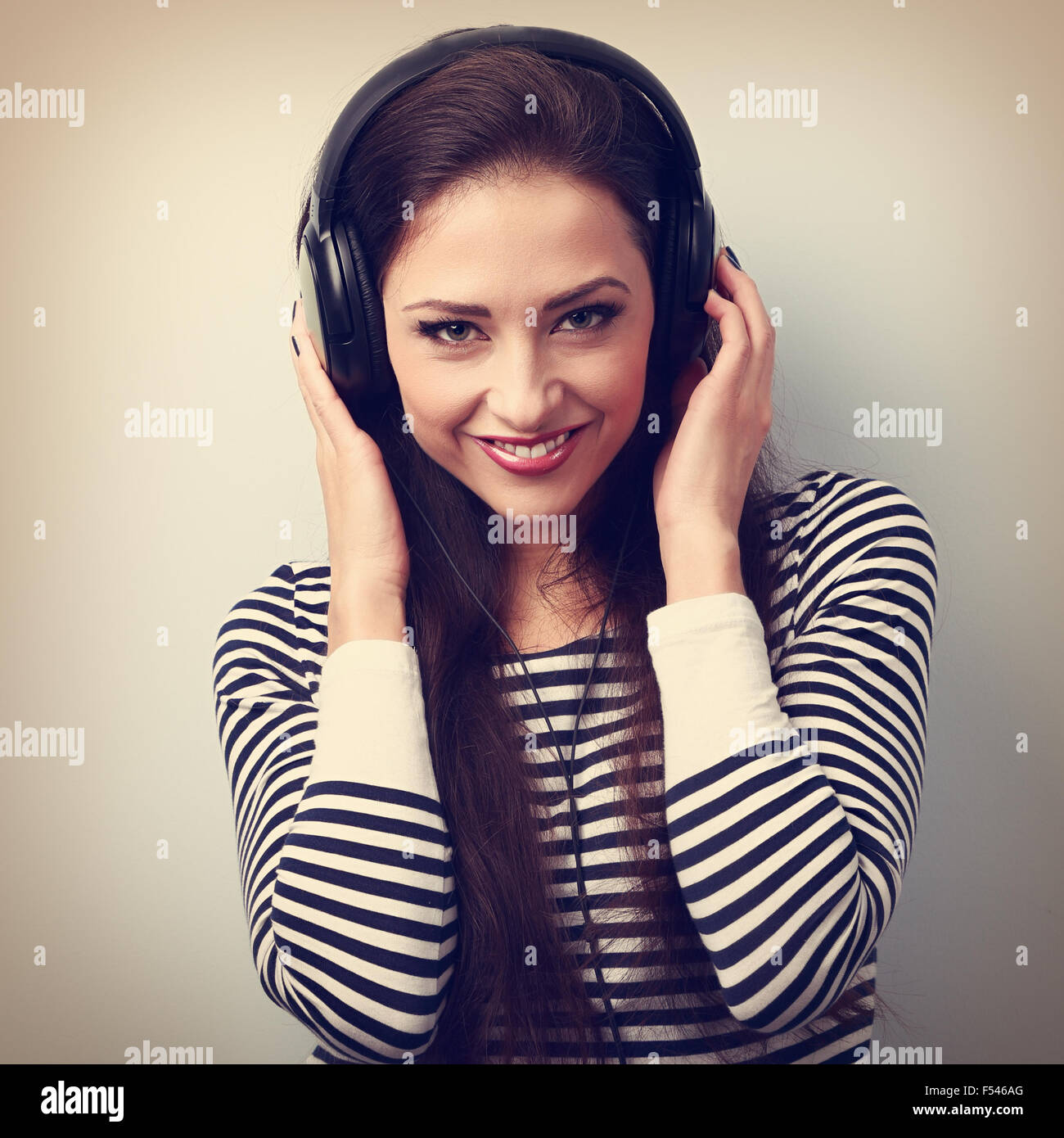 Feliz natural emoción mujer escuchando la música la celebración de las manos de los auriculares. Retrato Vintage Foto de stock