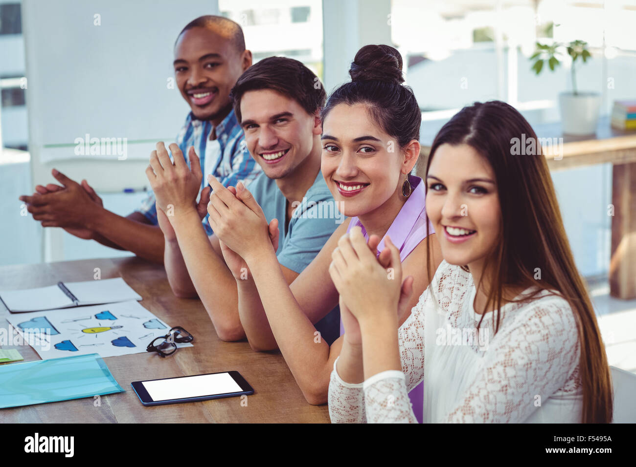 En la reunión del equipo de negocio creativo aplaudiendo Foto de stock