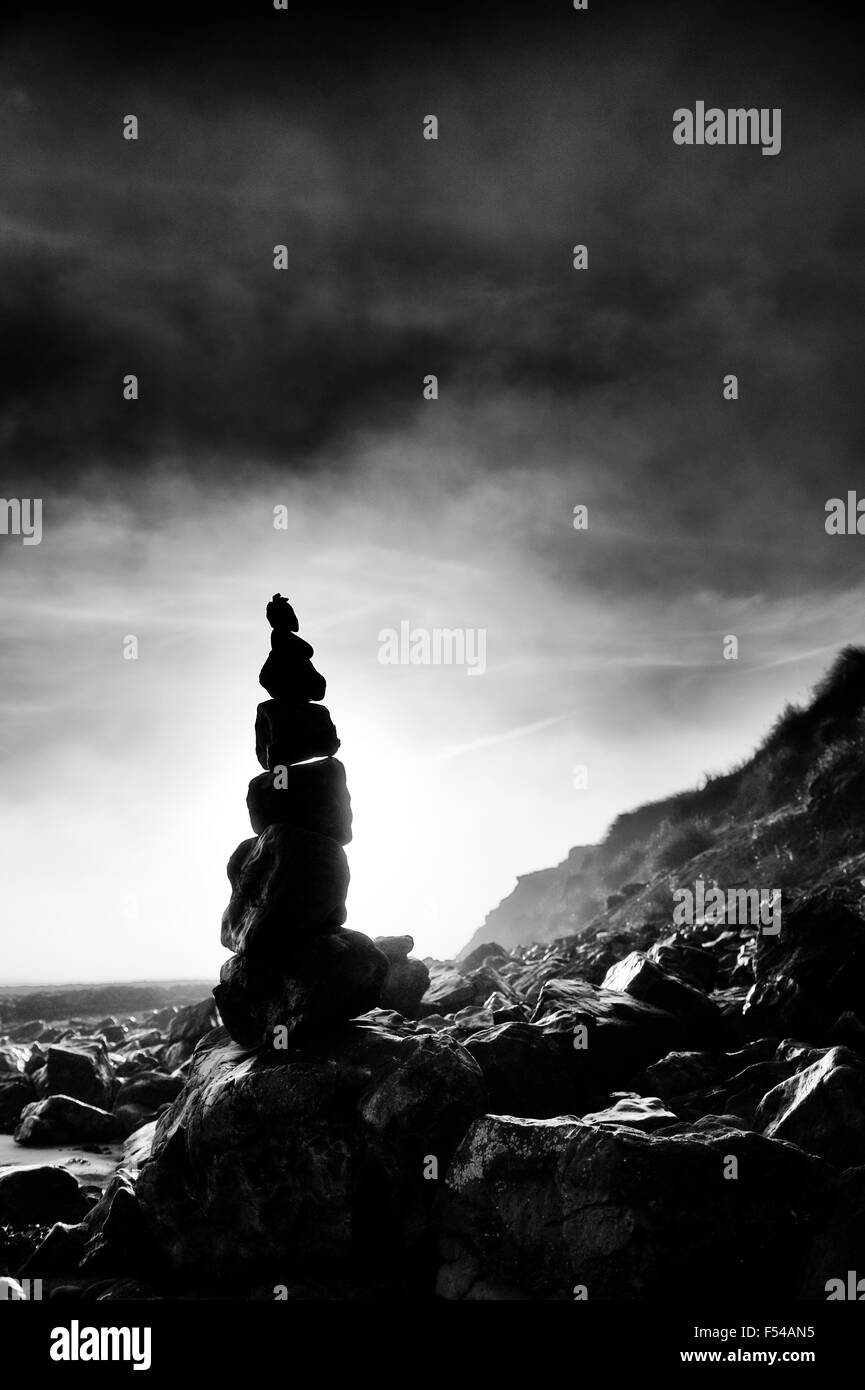 Equilibrio de piedras en una playa. Scremerston, Berwick Upon Tweed, Northumberland, Inglaterra. Blanco y negro Foto de stock