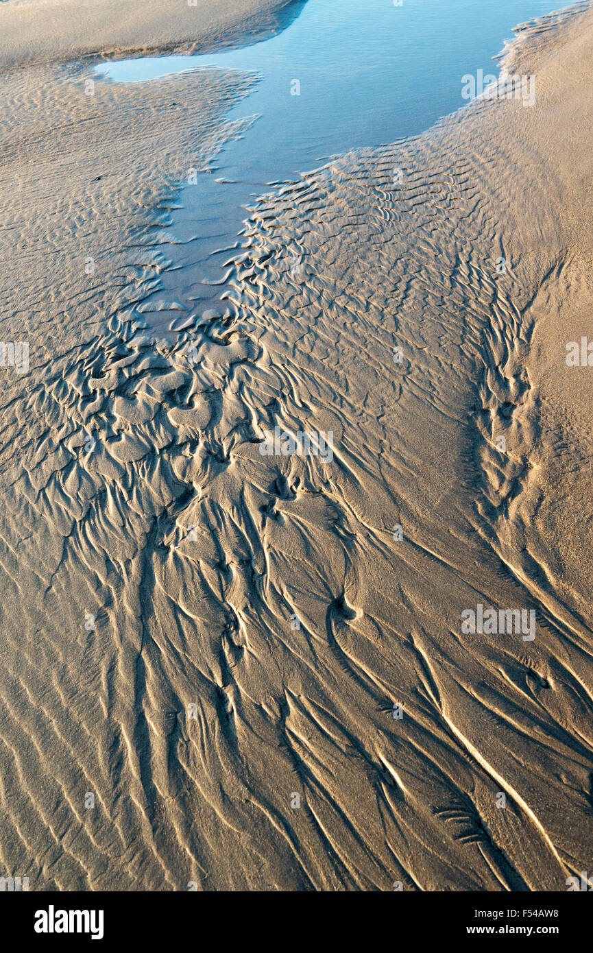 Arena ondulada y el agua del mar en una playa con marea baja. Foto de stock
