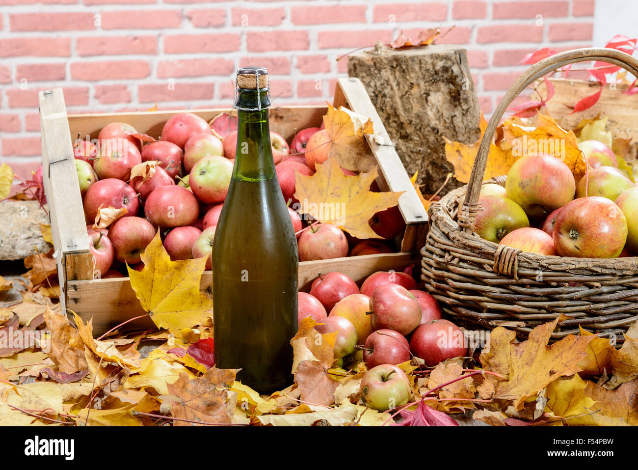 Una botella de sidra de Normandía, con muchas manzanas y cesta Foto de stock