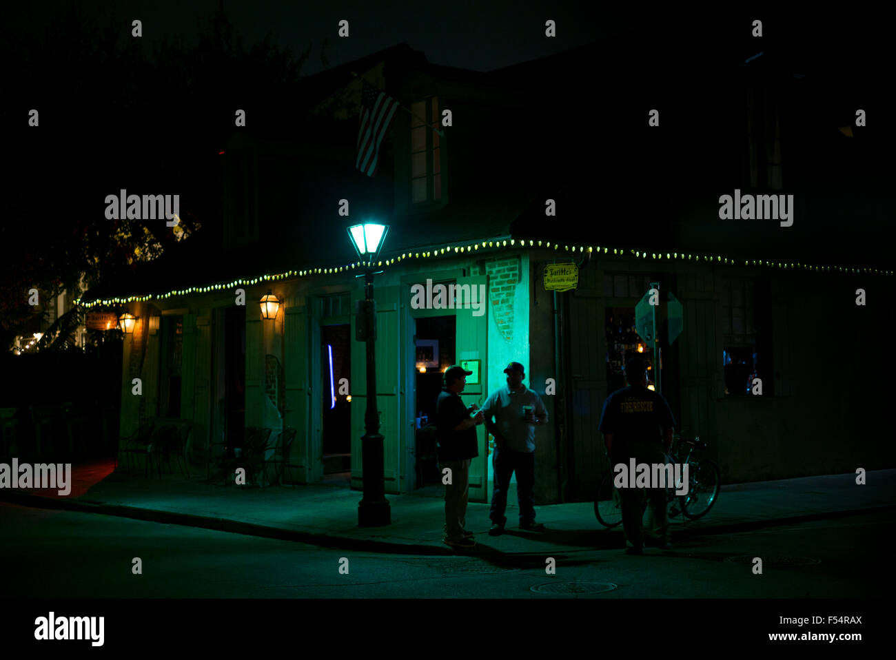 Los hombres chatear por jazz bar en la esquina de la calle en la Calle Bourbon en el French Quarter de Nueva Orleans, EE.UU. Foto de stock