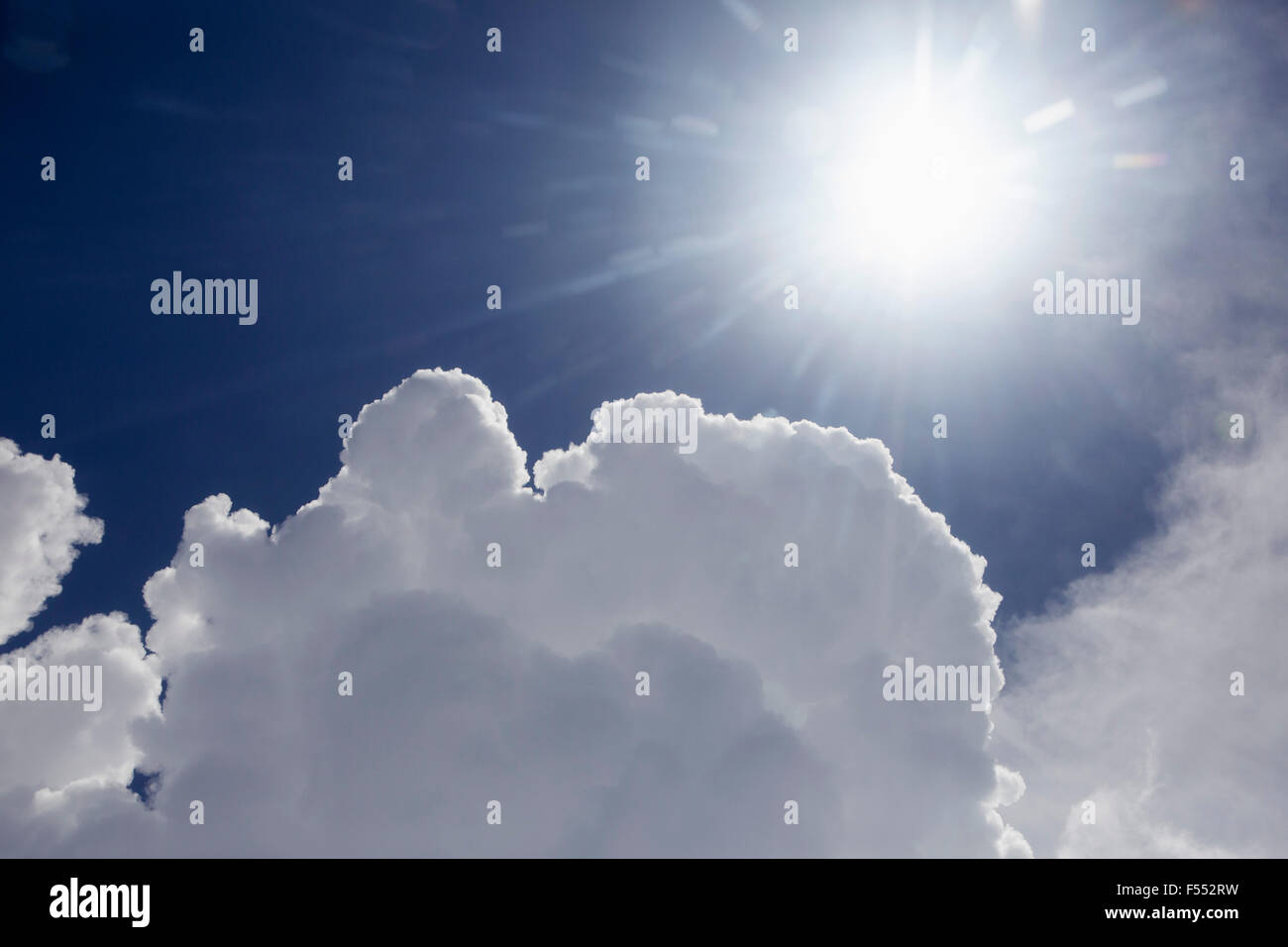 Vista de ángulo bajo el sol brillante en el cielo nublado Foto de stock