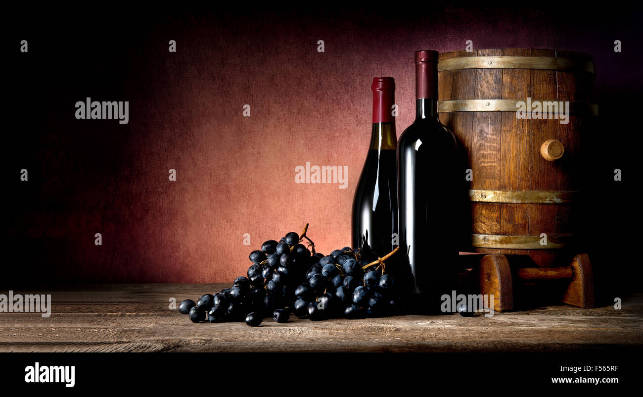 Botellas de vino con barrica y uva Foto de stock