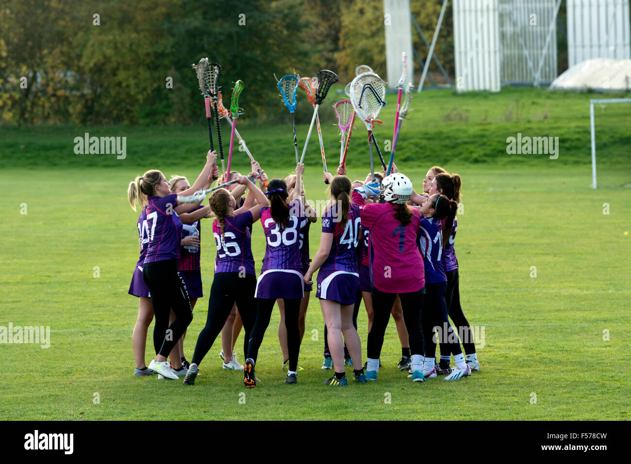 Deporte universitario - señoras lacrosse en la Universidad de Warwick, Reino Unido. Pre-play motivacional del equipo elevación de palos. Foto de stock