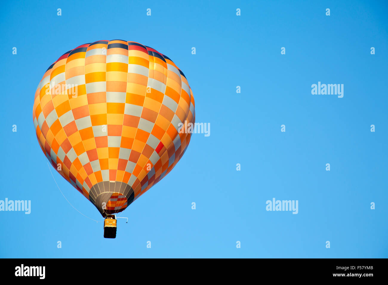 Multicolor en globo de aire caliente flotando en el cielo azul Foto de stock