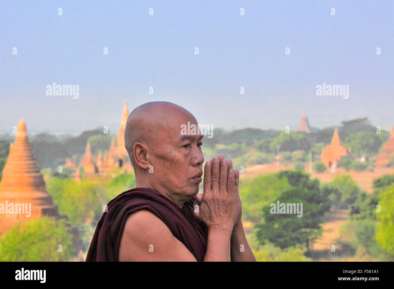 Monje budista rezando en la parte superior de la pagoda Shwesandaw en Bagan, Myanmar antes conocido como Birmania Foto de stock