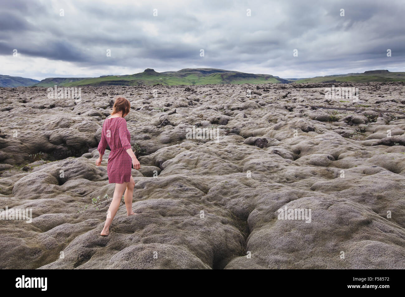 Moda Mujer caminar descalzo en campos de lava en Islandia Foto de stock
