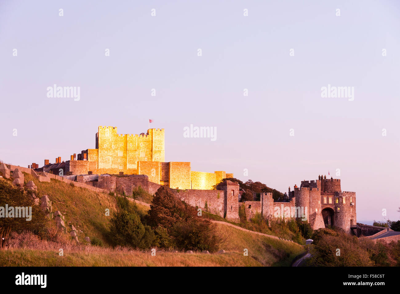 Inglaterra, al castillo de Dover. Mantener y castillo bañado en malva difusa durante el resplandor azul crepúsculo hora. Mantener, de color dorado, iluminado por reflectores. Foto de stock