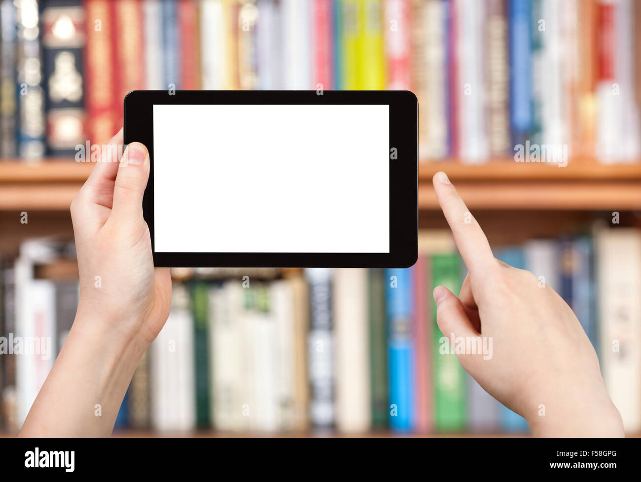 Asideros tablet pc con pantalla de corte y estantes de libros sobre antecedentes Foto de stock