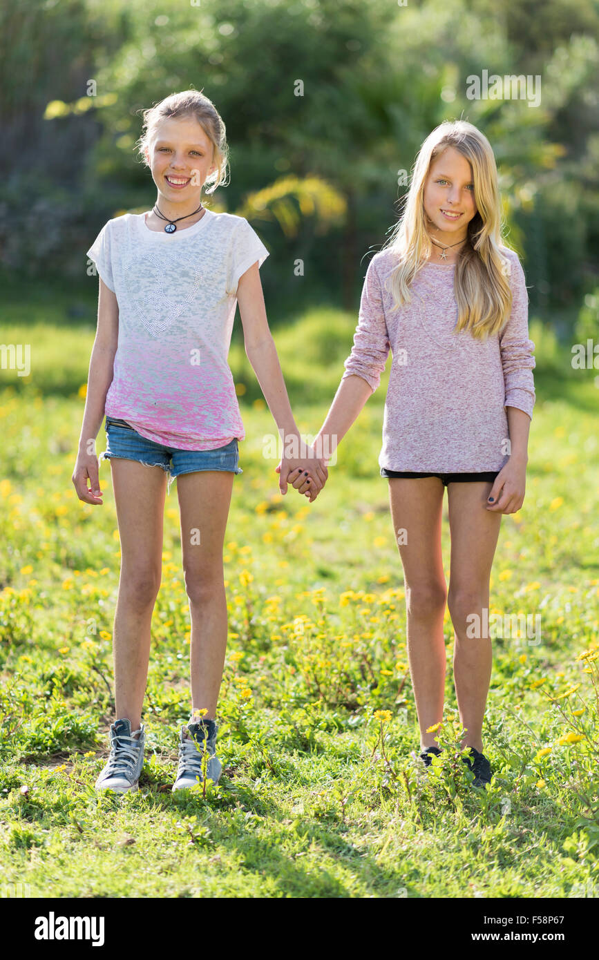 Twin sisters holding hands fotografías e imágenes de alta resolución