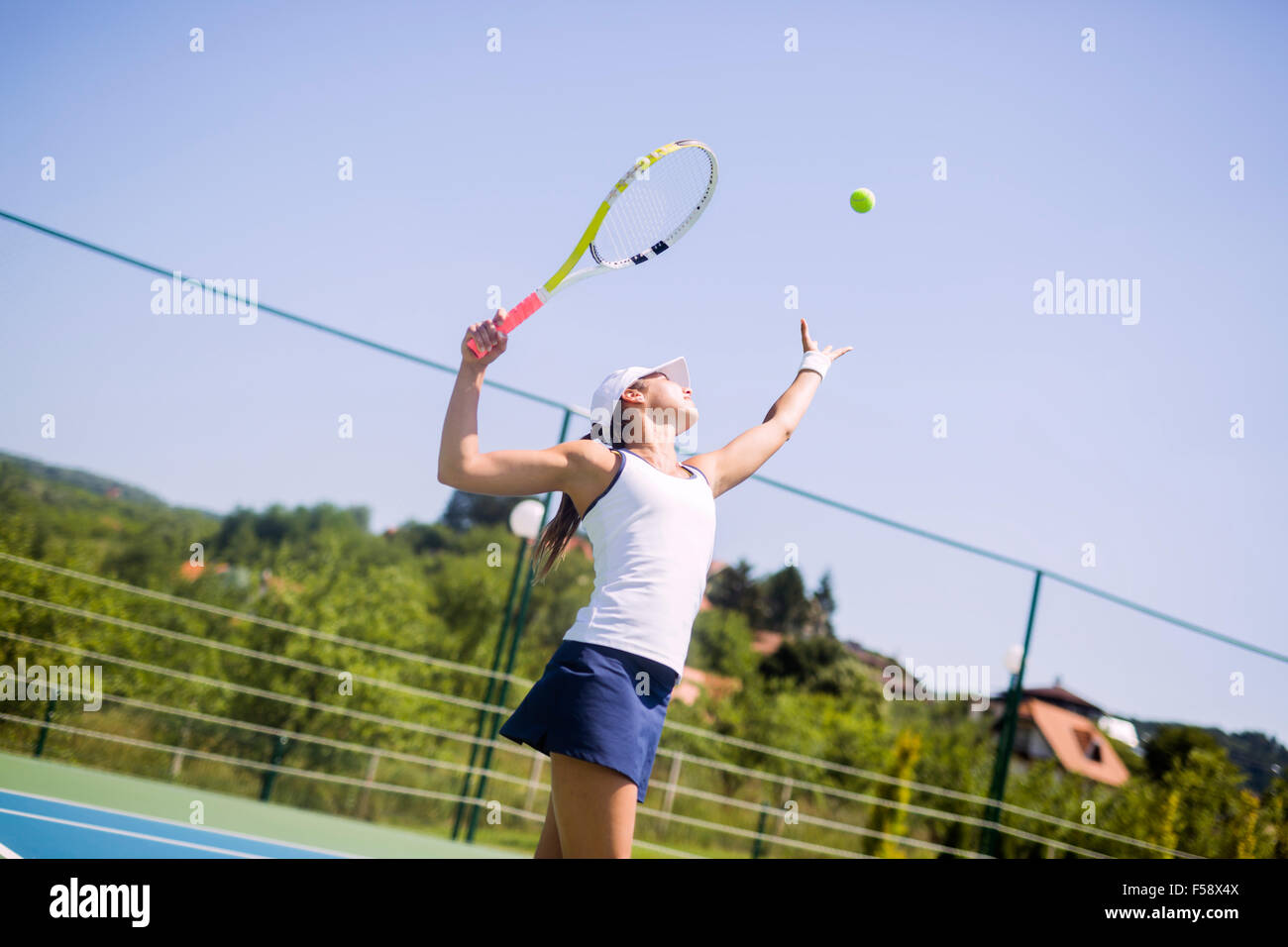 Jugador de tenis femenino hermoso sirviendo outdoor Foto de stock