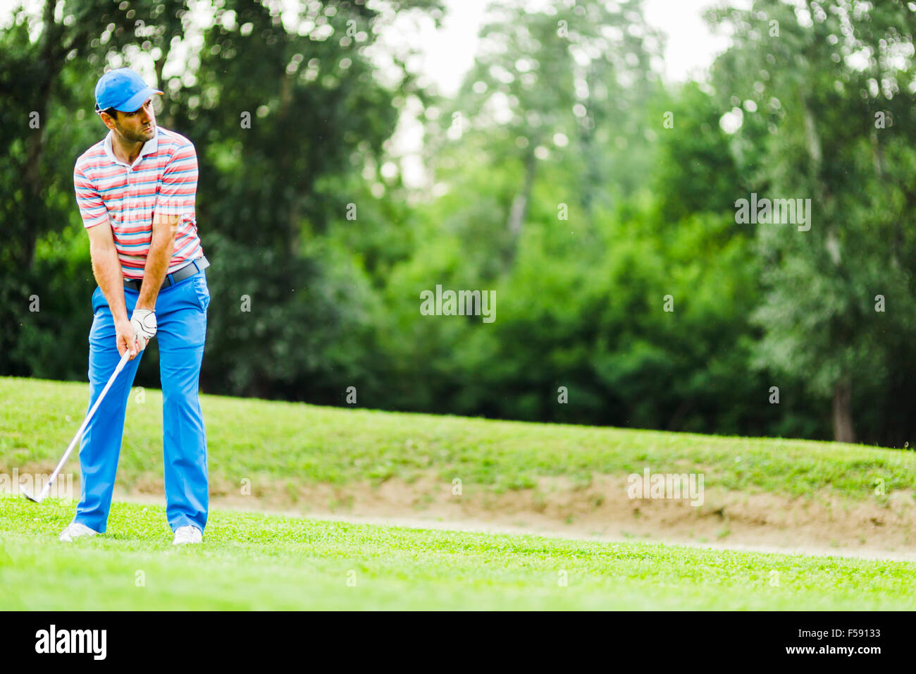 Golfista practicando y concentrar antes y después del disparo durante un día soleado Foto de stock
