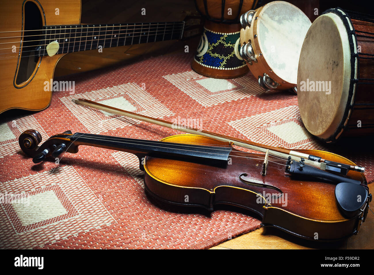 Violín gitano, guitarra acústica y percusión en azulejos, alfombras de  estilo folk de los Balcanes y de Europa Fotografía de stock - Alamy