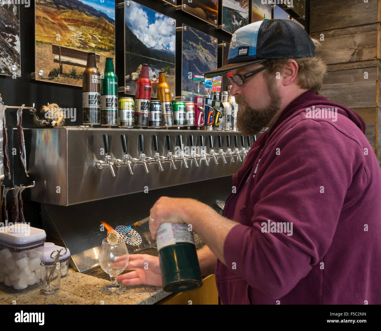 Barman Chris Grant tostadas un malvavisco para servir con un s'more Stout en el Campamento Base Brewing Company, sureste de Portland, Oregón Foto de stock