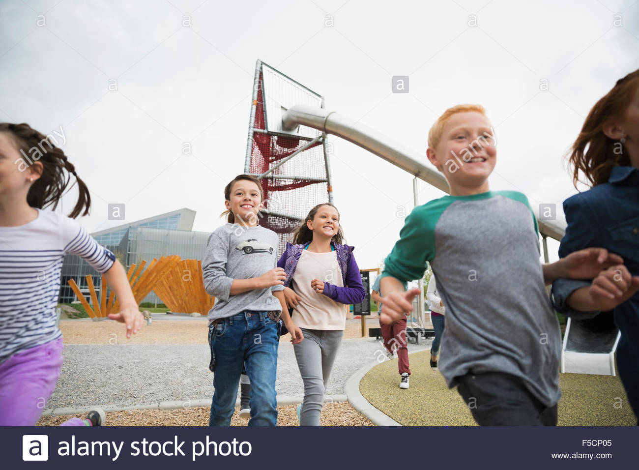 Entusiastas niños corriendo en el patio Foto de stock