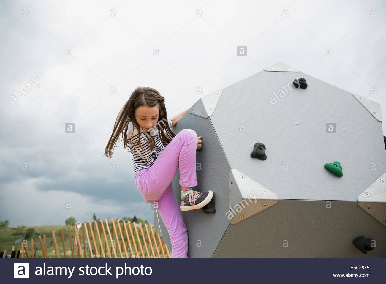 Chica escalada forma geométrica en playground Foto de stock