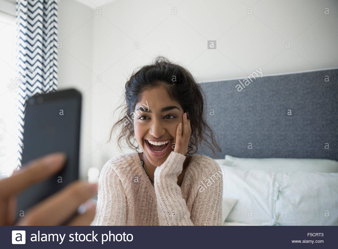 Joven entusiasta teniendo selfie en la cama Foto de stock