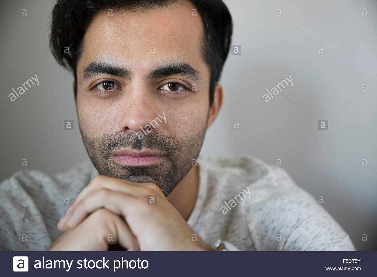 Retrato hombre serio con pelo negro y rastrojo Foto de stock