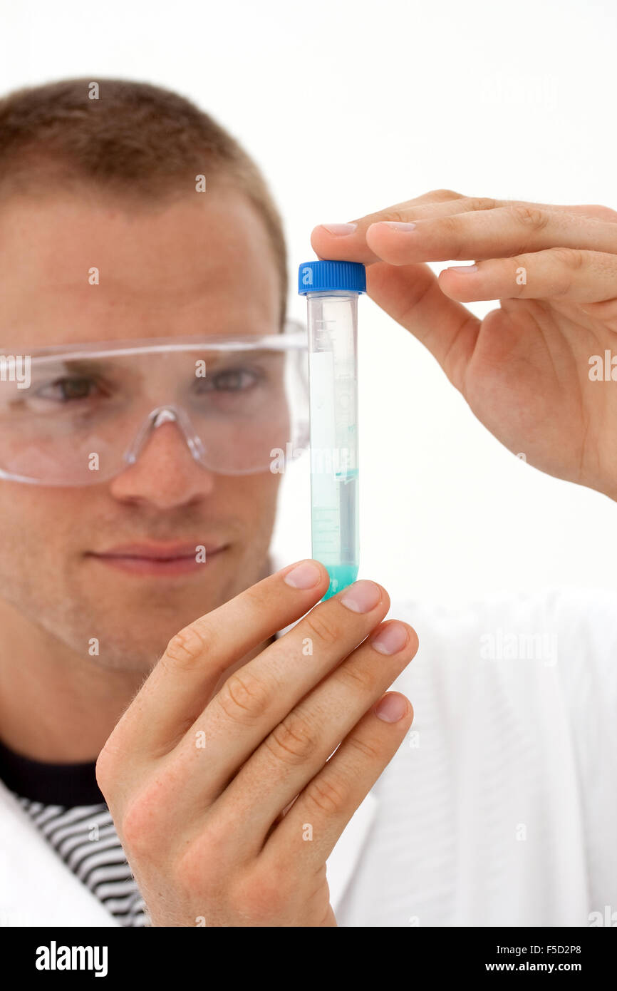 Técnico de laboratorio mirando a tubo de ensayo - centrarse en las manos y tubo de ensayo Foto de stock