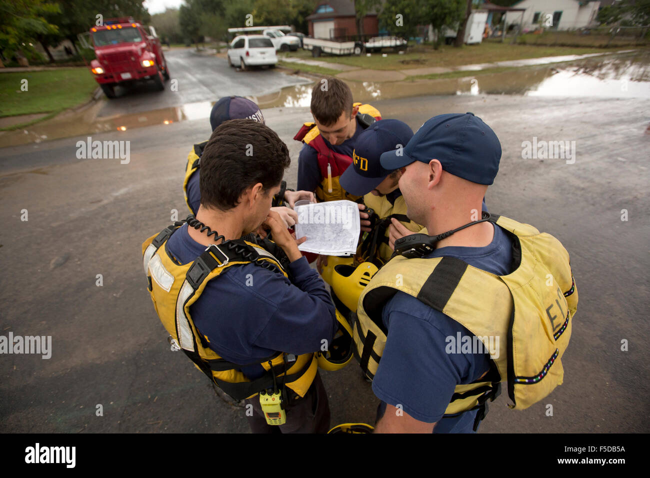 Austin bomberos se apiñan para ver un mapa del barrio Onion Creek. El riachuelo inundado anteriormente en el día después de que el área r Foto de stock