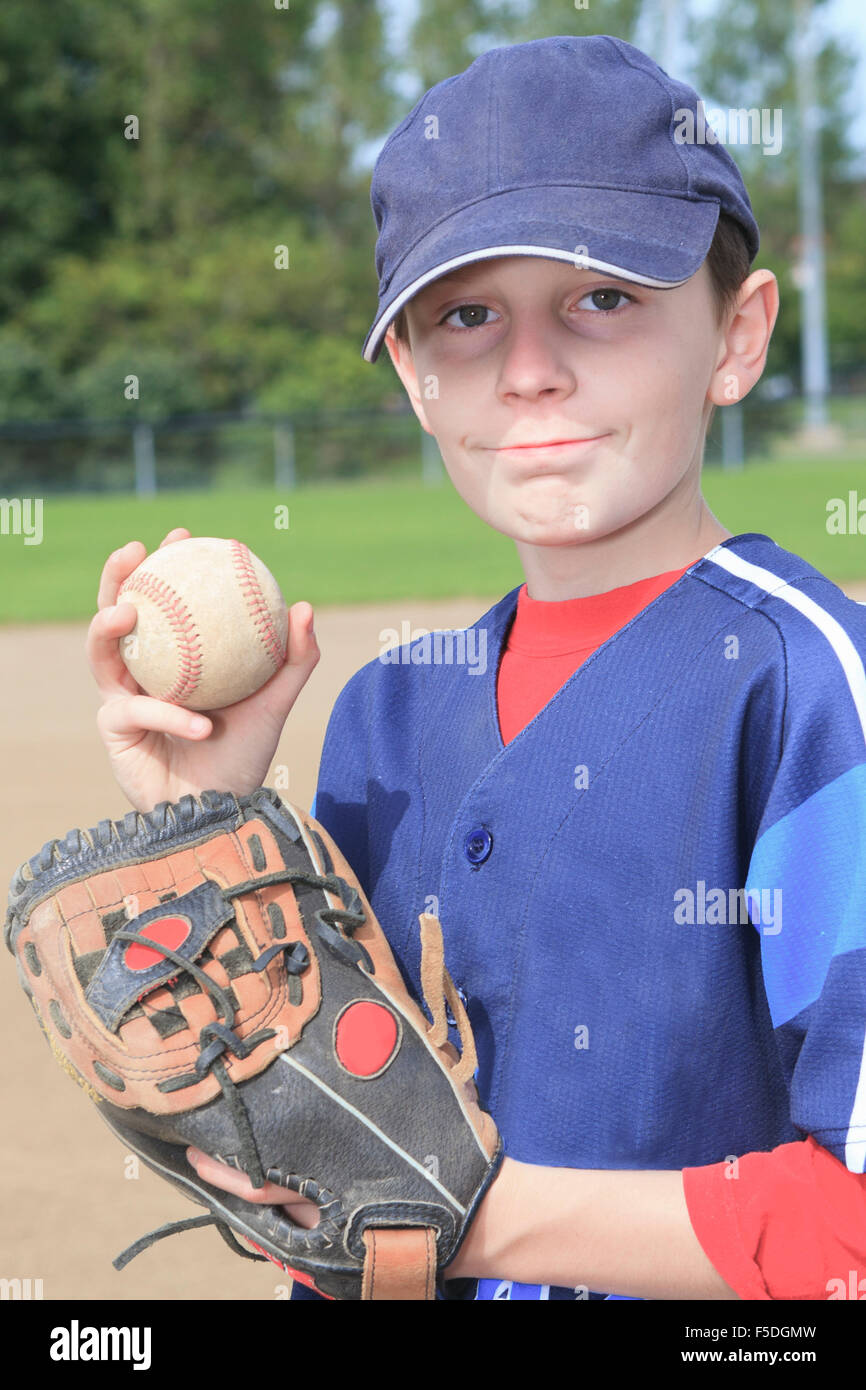 Niño pitchen de béisbol en el campo Foto de stock