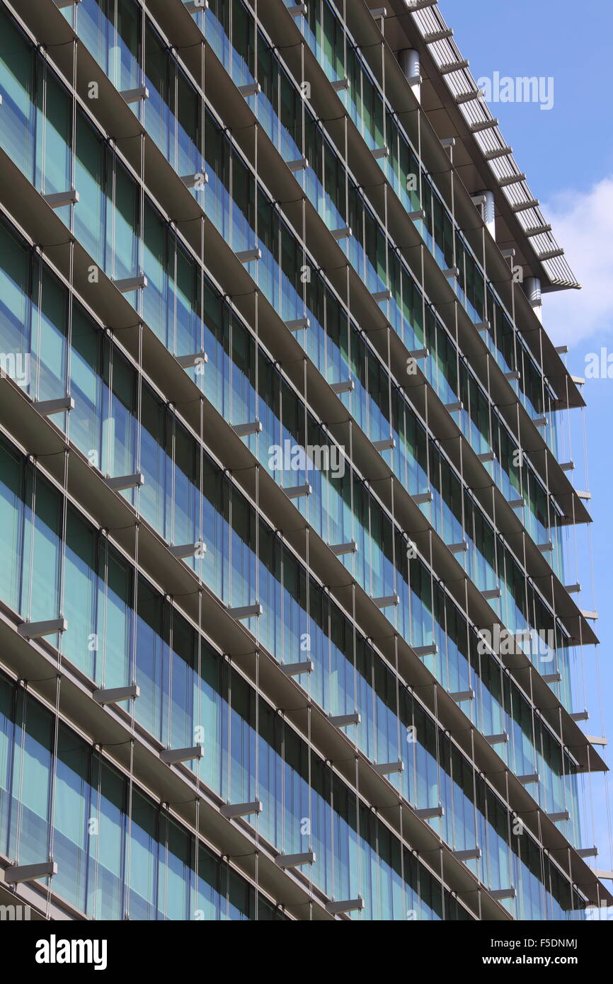 Una vista lateral de un bloque de oficinas moderno mirando hacia los lados y hacia arriba a lo largo de todas las ventanas que muestran los cables de suspensión Foto de stock