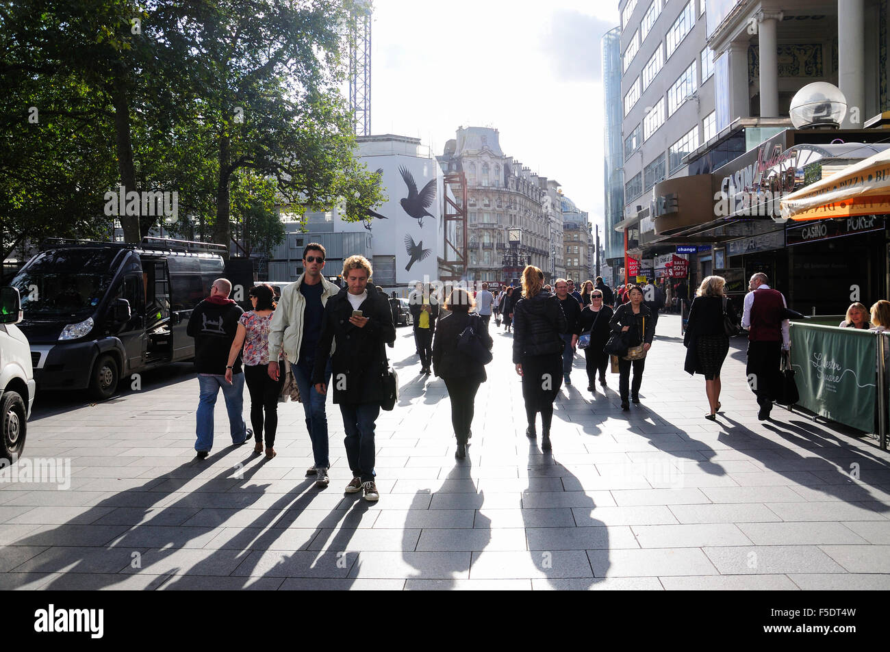 Los peatones caminando a través de Leicester Square, el West End, la ciudad de Westminster, London, England, Reino Unido Foto de stock