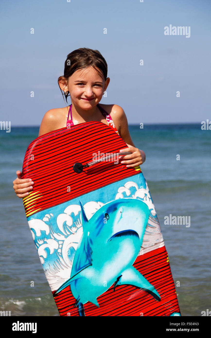 Chica en la playa con tablet surf Foto de stock