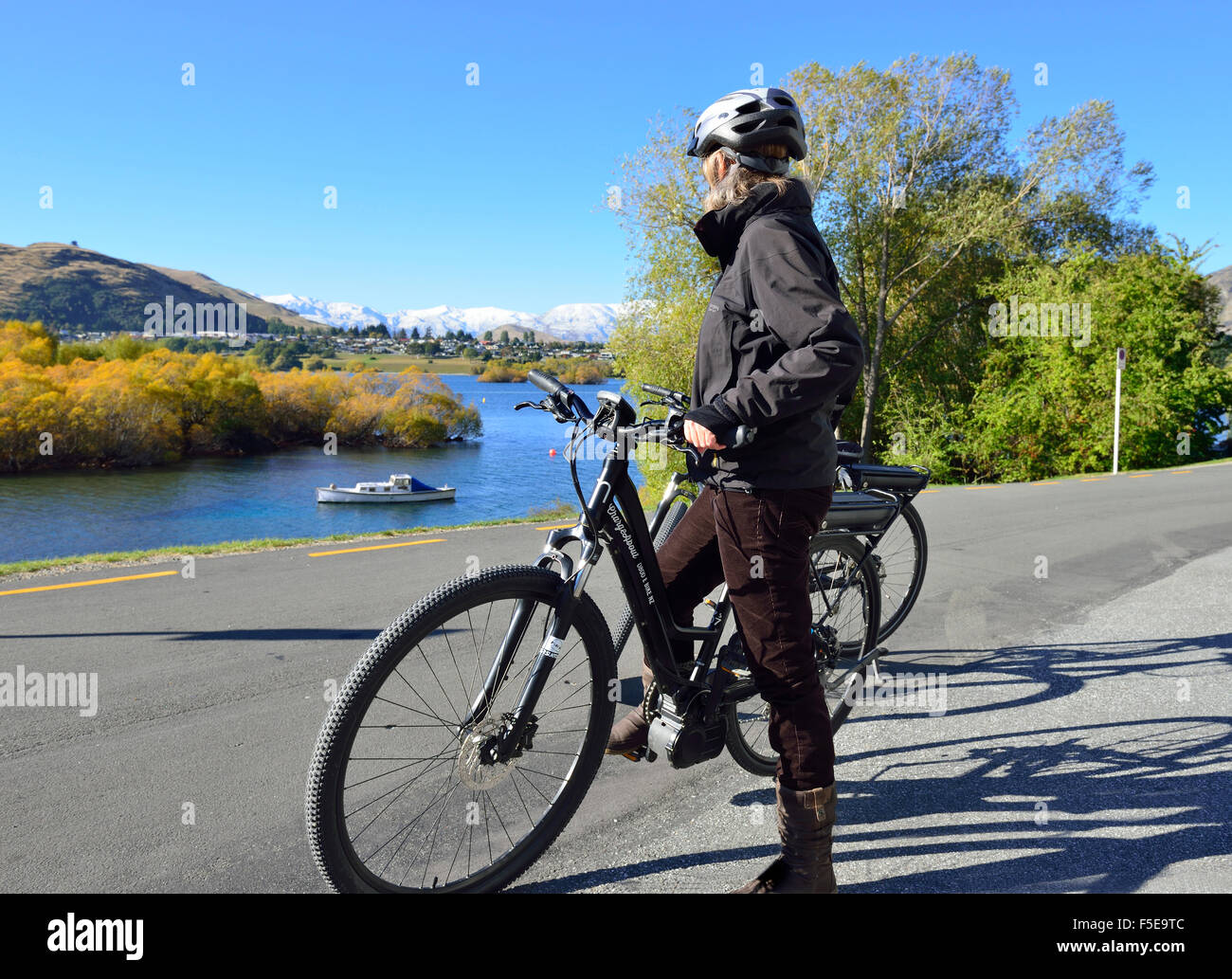 Señora ciclista sobre una bicicleta eléctrica,E-bike, mirando el paisaje a  orillas del Lago Wanaka, Frankton, Nr de Queenstown, Isla del Sur, Nueva  Zelanda Fotografía de stock - Alamy