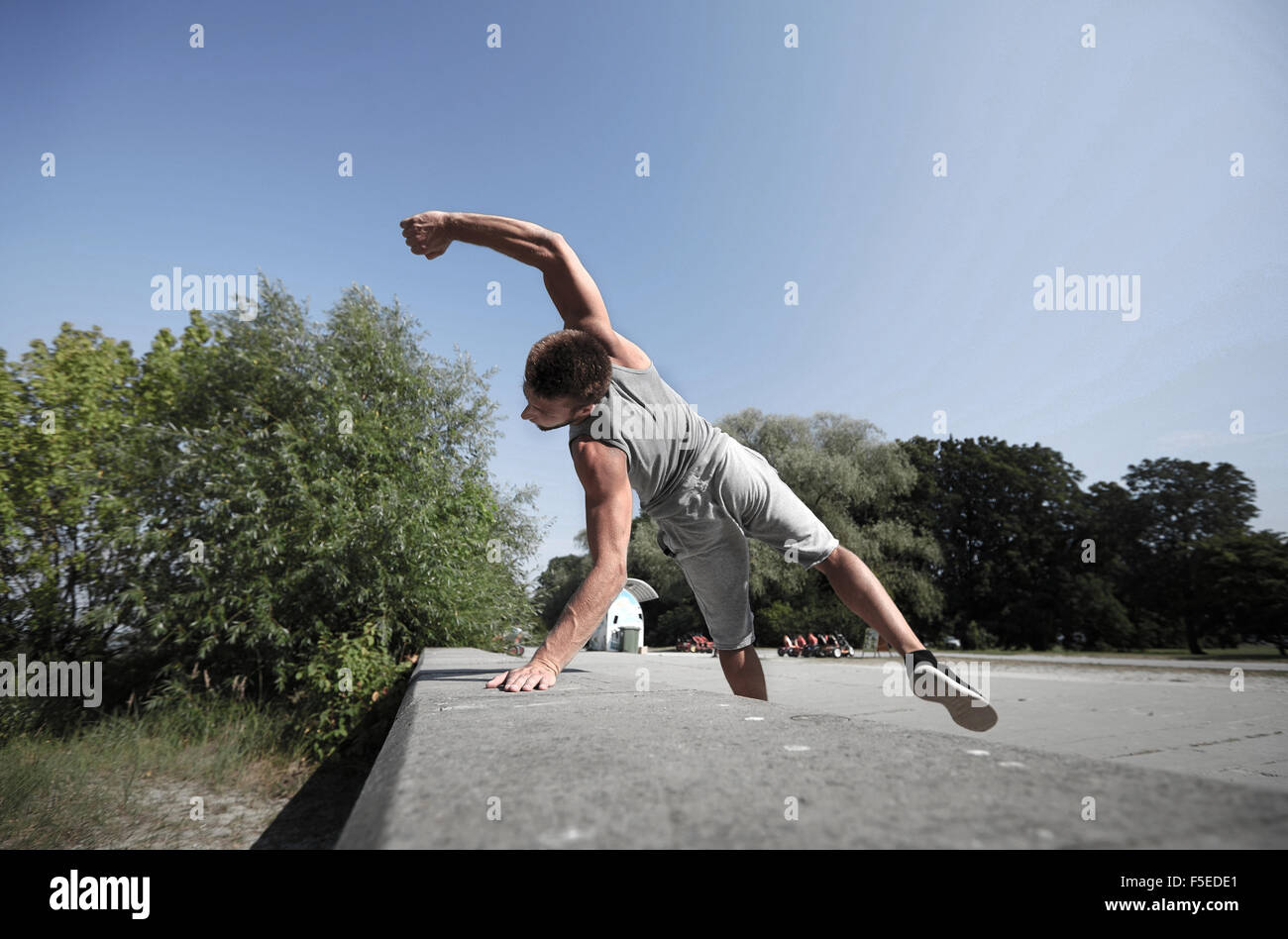 Deportivo joven saltando en verano park Foto de stock