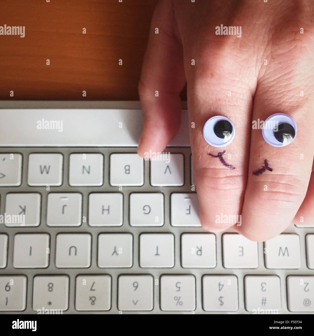 Google ojos y cara sonriente dibujada en un lado, escribiendo en el teclado  Fotografía de stock - Alamy