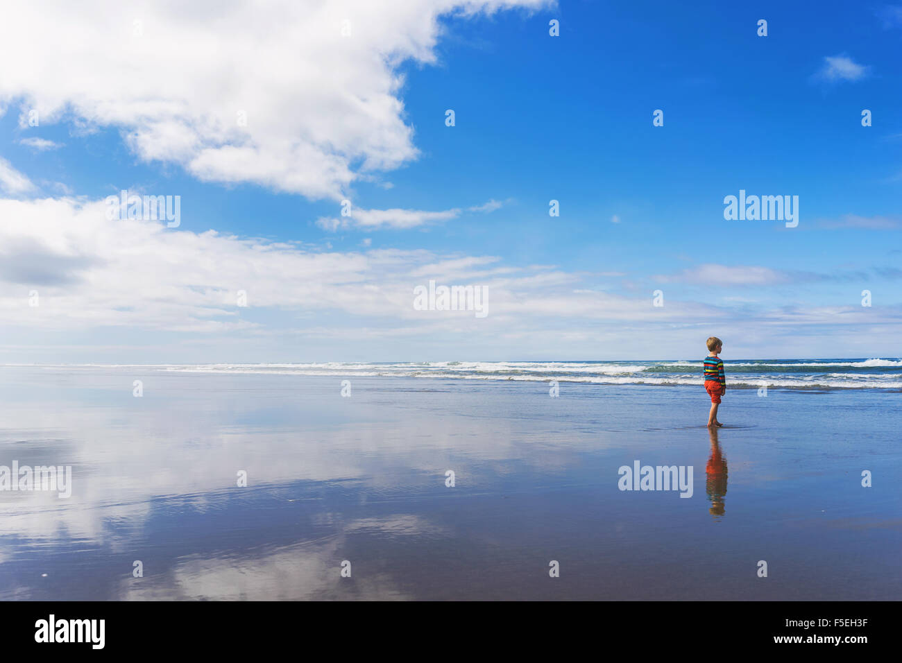 Niño de pie en la playa Foto de stock