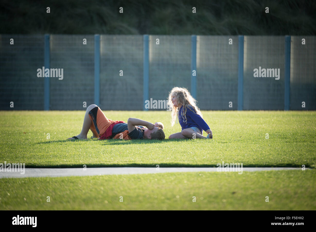 Niño y niña hablando en un campo de fútbol Foto de stock