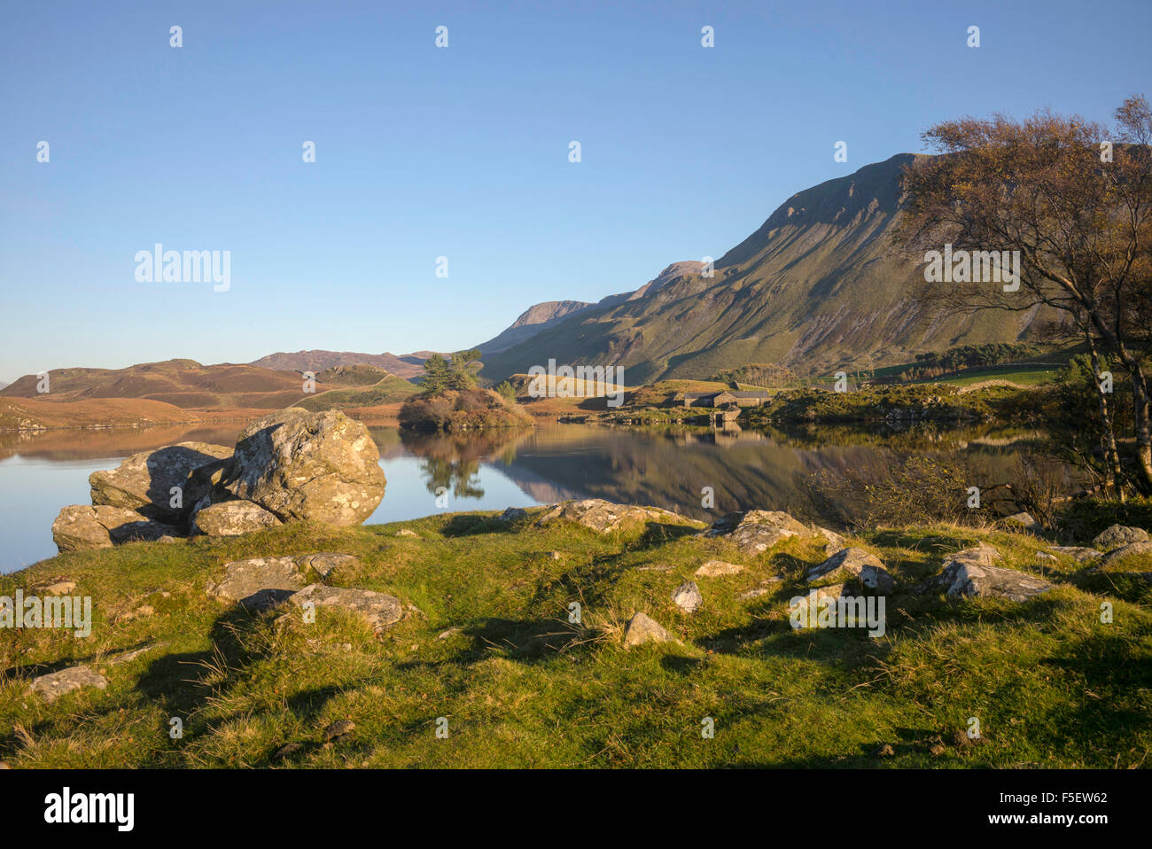 A finales de otoño Sol en Lagos Cregennan ignorada por el Cader Idris cordillera reflejado en los tranquilos lagos Foto de stock