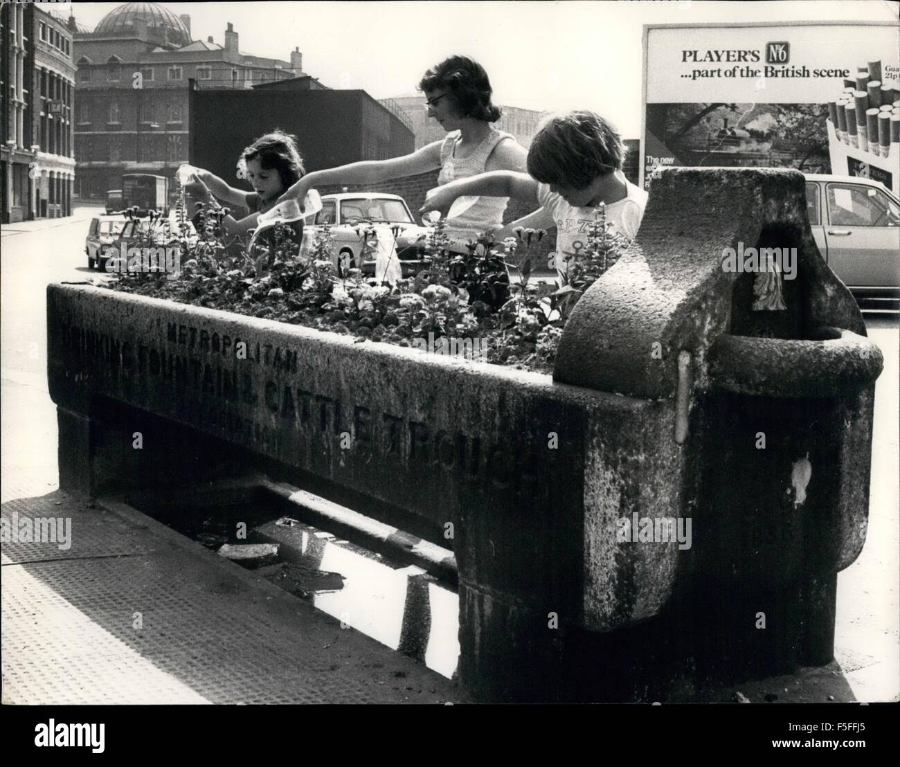 1967 - Ahora su las flores que obtenga una bebida: una reliquia del pasado, una fuente de agua potable y abrevadero de ganado, que se ha convertido en miniatura de un jardín de flores, es atendido por jóvenes con botellas de leche para regar las flores - Escena en Farringdon Road, Londres. © Fotos Keystone USA/ZUMAPRESS.com/Alamy Live News Foto de stock