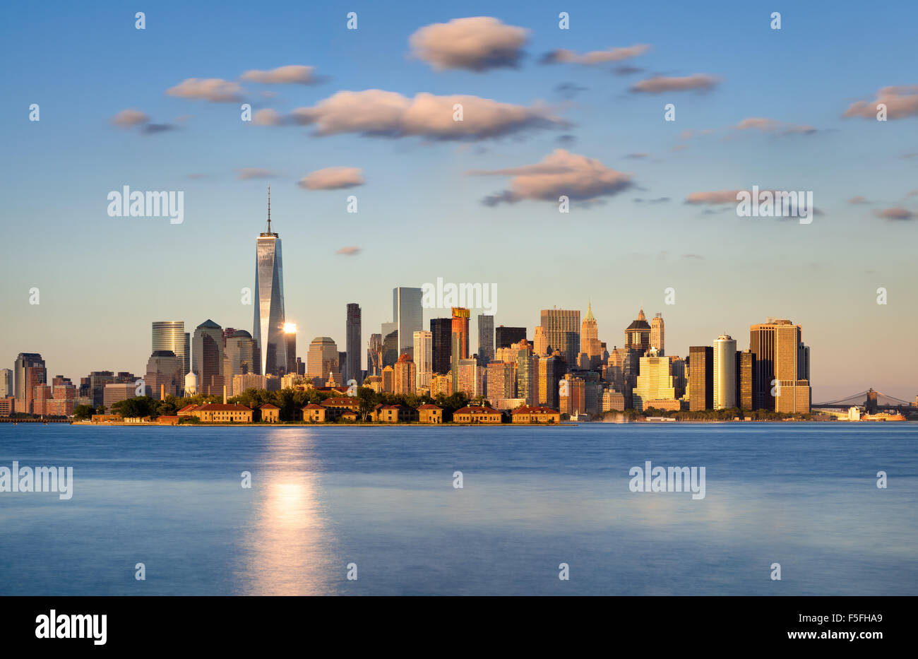 El horizonte de la ciudad de Nueva York, Manhattan. Ellis Island aparece delante de los rascacielos del distrito financiero Foto de stock