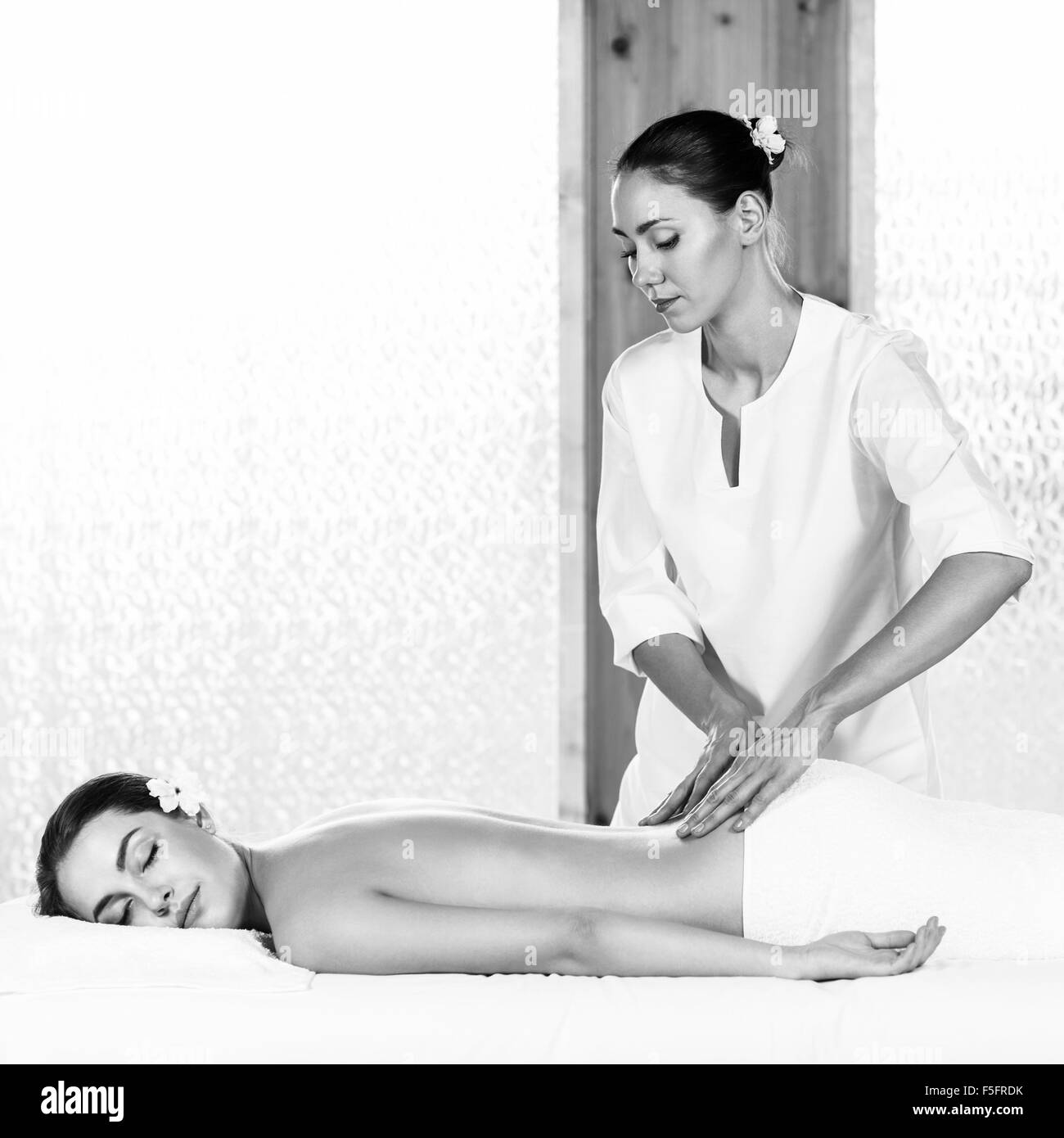 Hermosa morenita mujer disfrutando de un masaje de espalda en el health spa Foto de stock