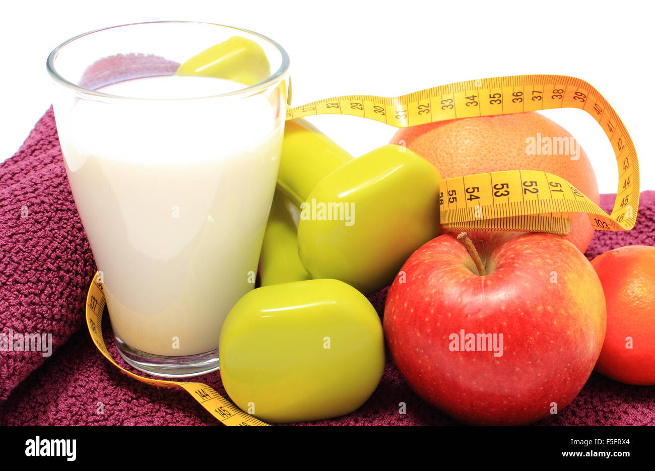 Fruta en un vaso, una campana y una cinta para medir el cuerpo