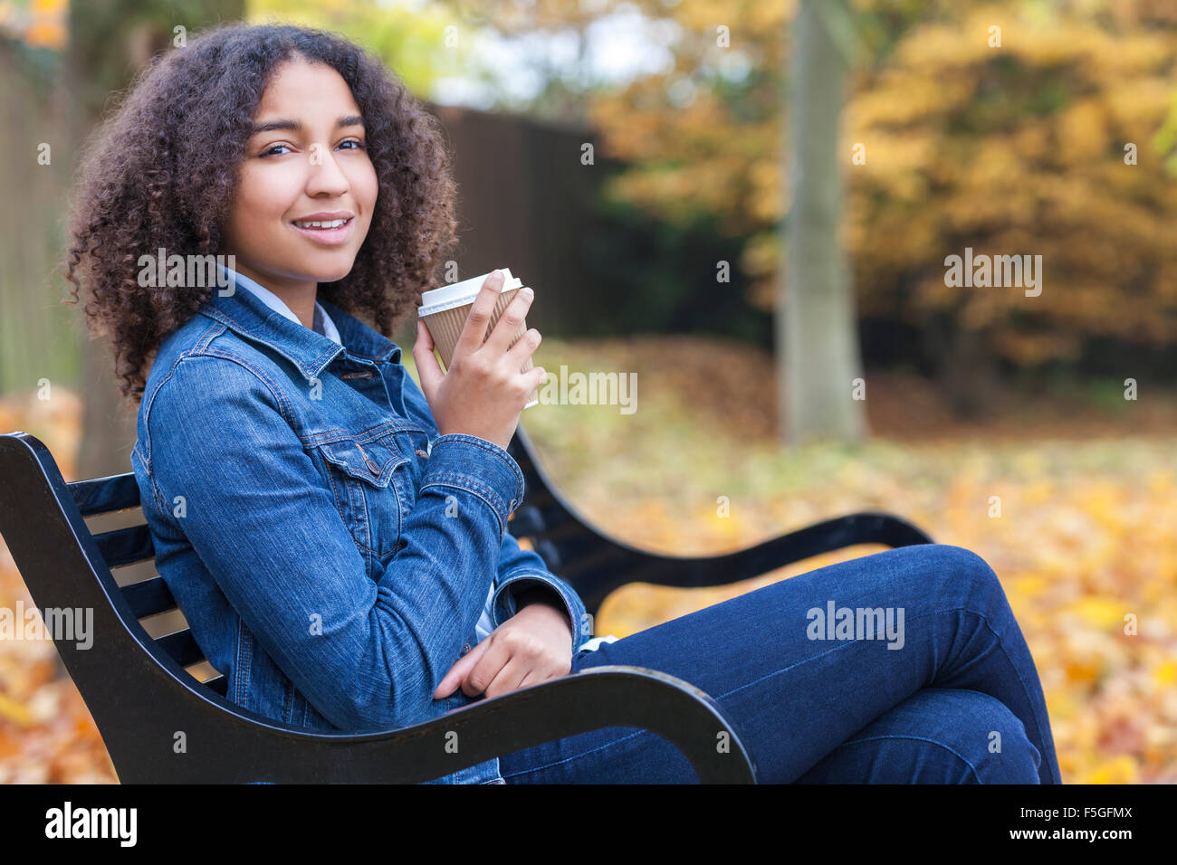 Feliz hermosa chica americana africana de raza mixta femenina adolescente  joven sonriente y beber café fuera de comida para llevar Fotografía de  stock - Alamy