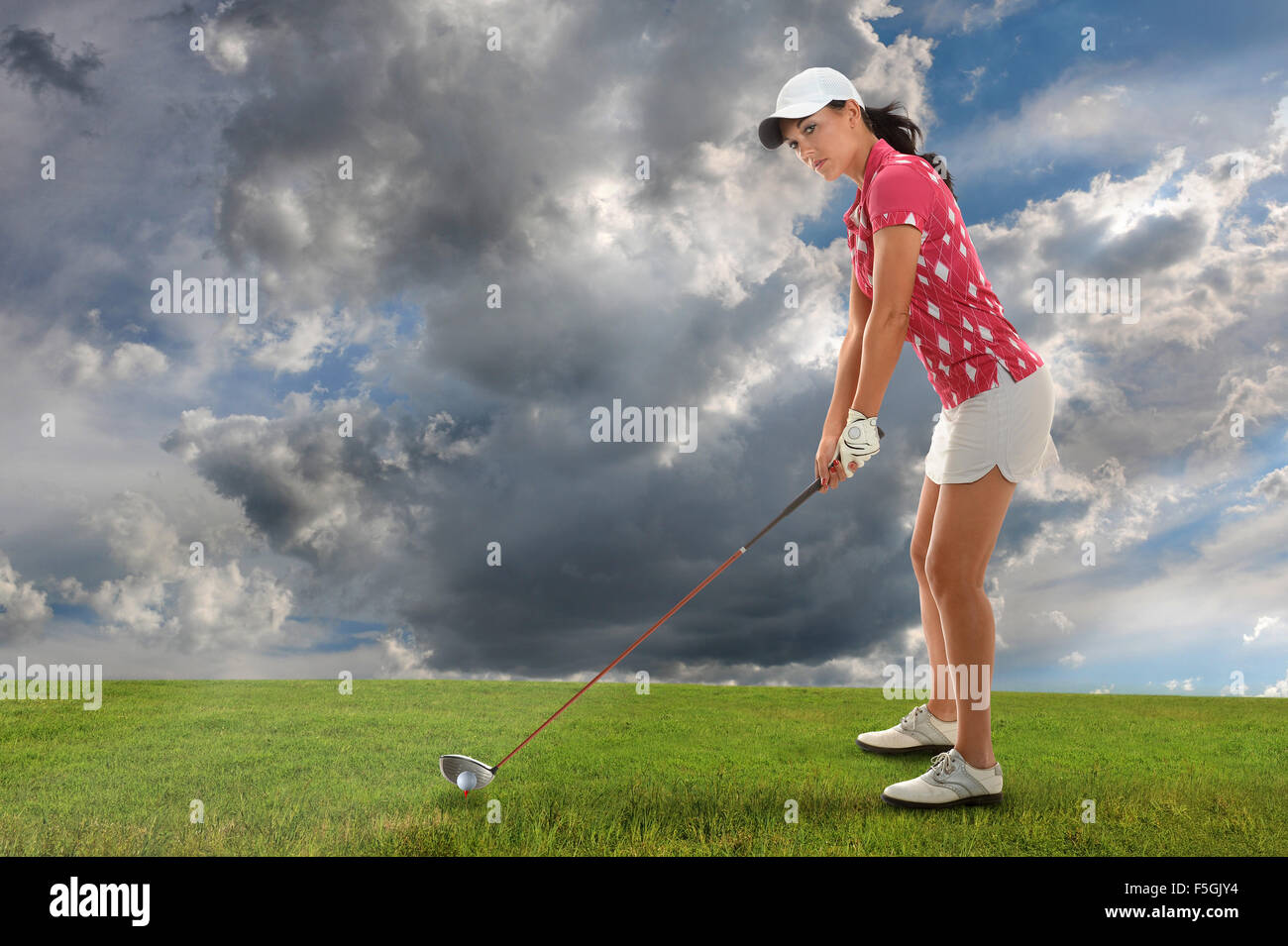 Hermosa joven jugando al golf con conductor Foto de stock