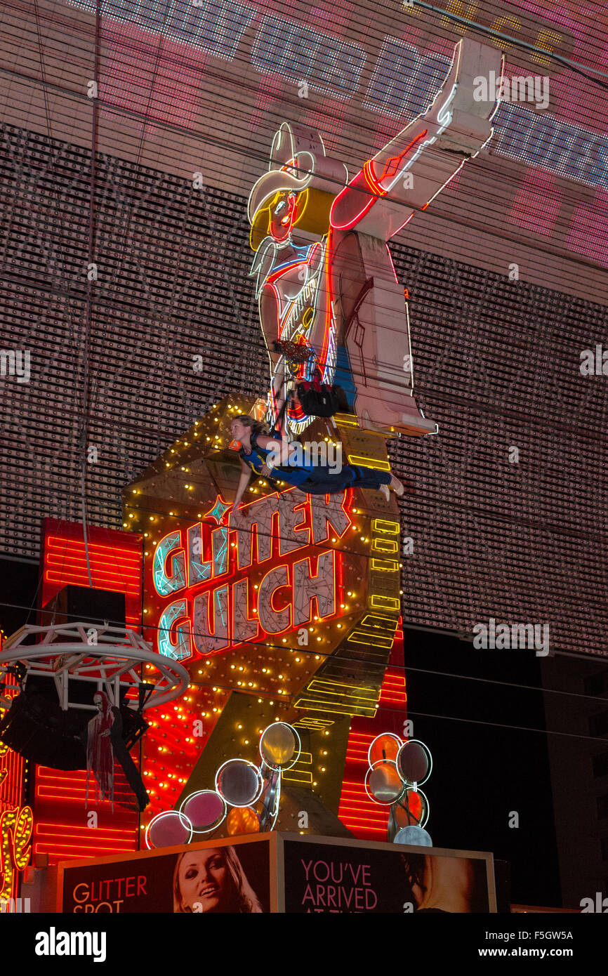 Las Vegas, Nevada. Fremont Street. Glitter Gulch Cowgirl signo, con Zipline Rider pasando. Foto de stock