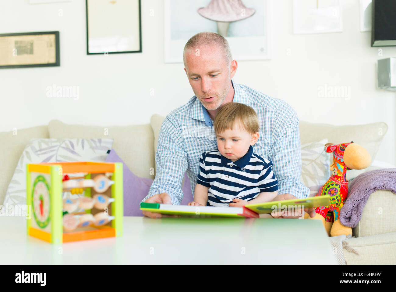 Suecia, hombre leyendo a su hijo (18-23 meses) Foto de stock